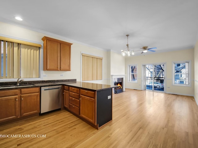 kitchen featuring stainless steel dishwasher, sink, kitchen peninsula, and light wood-type flooring