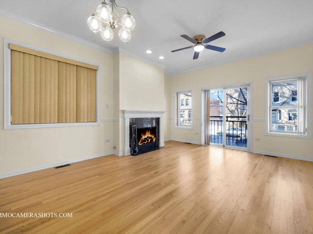 unfurnished living room featuring hardwood / wood-style floors, ceiling fan with notable chandelier, and ornamental molding