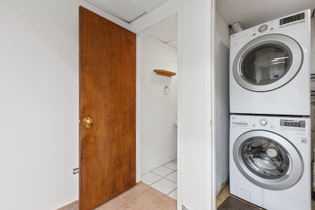 washroom with light tile patterned flooring and stacked washer and clothes dryer