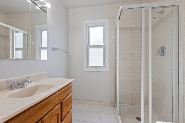 bathroom with vanity, walk in shower, a wealth of natural light, and tile patterned flooring