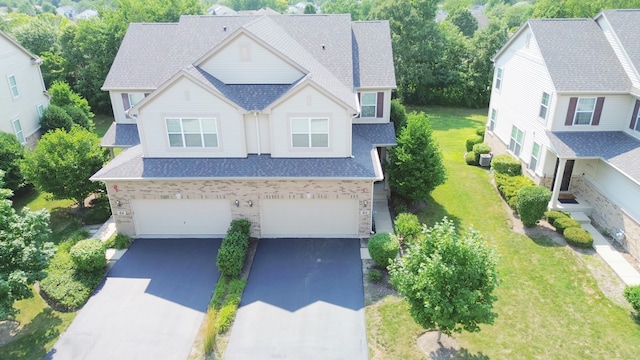 view of front facade with a front yard, cooling unit, and a garage