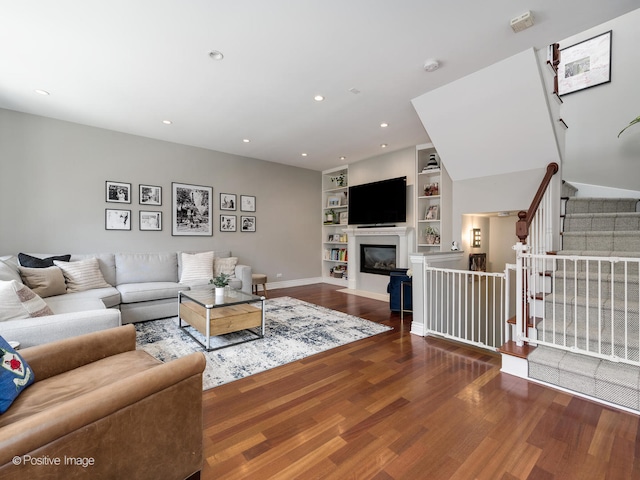 living room featuring built in shelves and hardwood / wood-style flooring