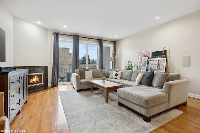 living room with a fireplace and light wood-type flooring