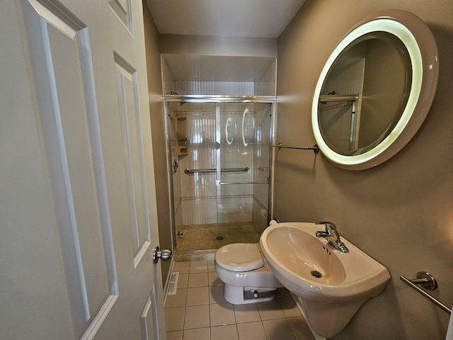 bathroom with tile patterned floors, a shower with shower door, and toilet