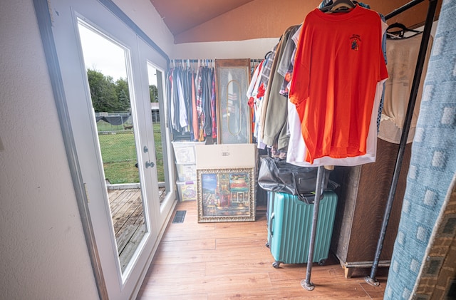 walk in closet with radiator, lofted ceiling, and light hardwood / wood-style floors