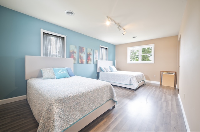 bedroom with dark wood-type flooring and rail lighting