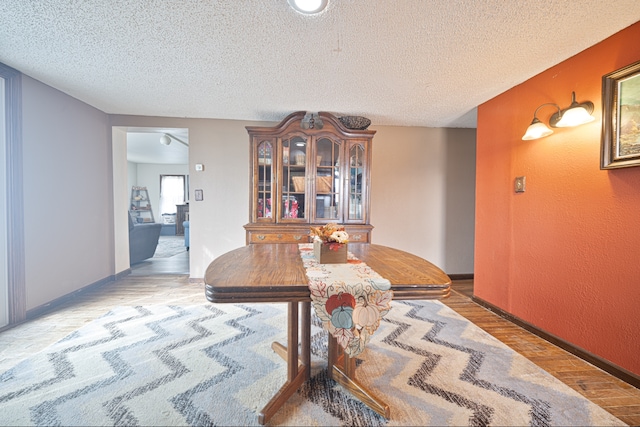 dining area with a textured ceiling and light wood-type flooring