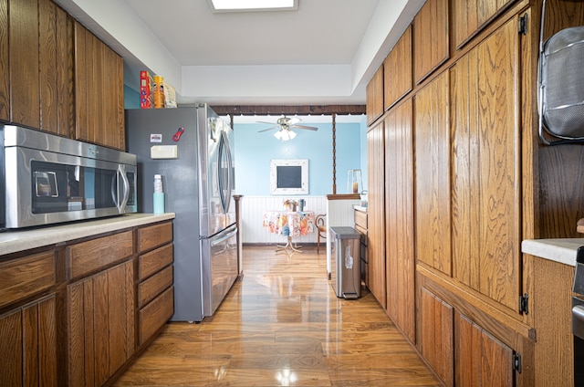 kitchen with light hardwood / wood-style floors, ceiling fan, and stainless steel appliances