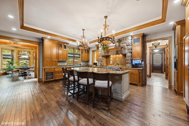 kitchen with a tray ceiling, dark hardwood / wood-style flooring, and a chandelier