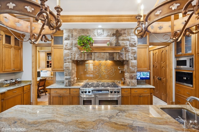 kitchen featuring light stone countertops, stainless steel appliances, backsplash, and sink