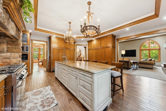 kitchen with an island with sink, appliances with stainless steel finishes, plenty of natural light, and white cabinetry