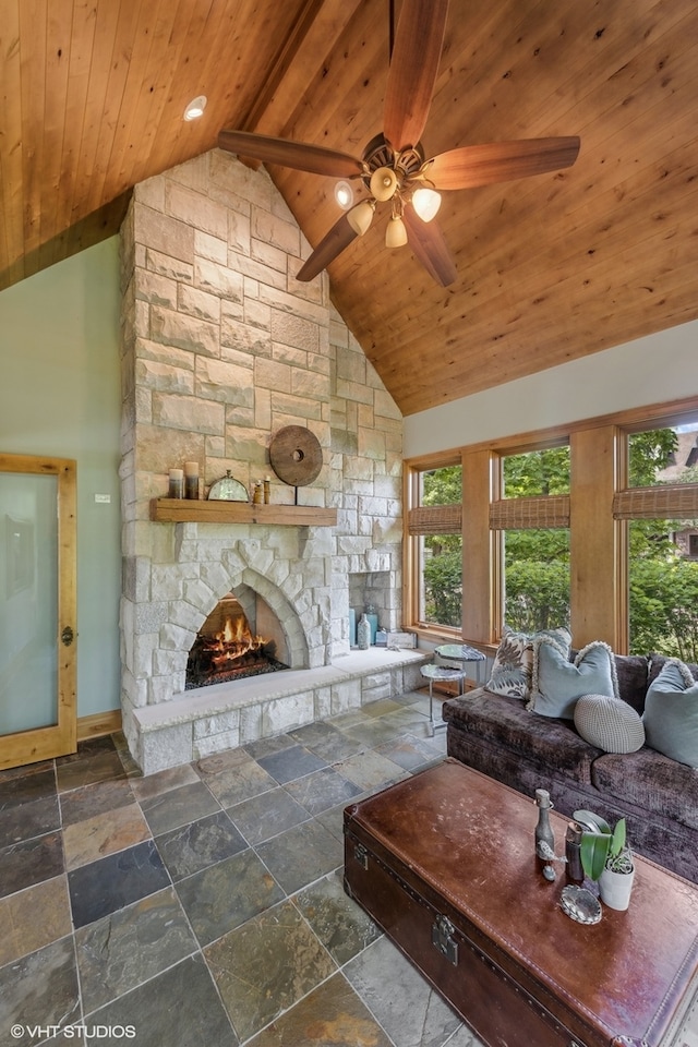 living room featuring ceiling fan, a stone fireplace, high vaulted ceiling, and wooden ceiling