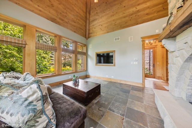 living room featuring a stone fireplace and high vaulted ceiling