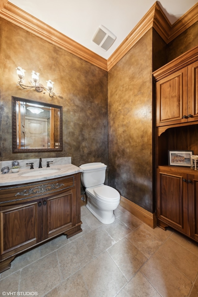 bathroom with ornamental molding, vanity, and toilet