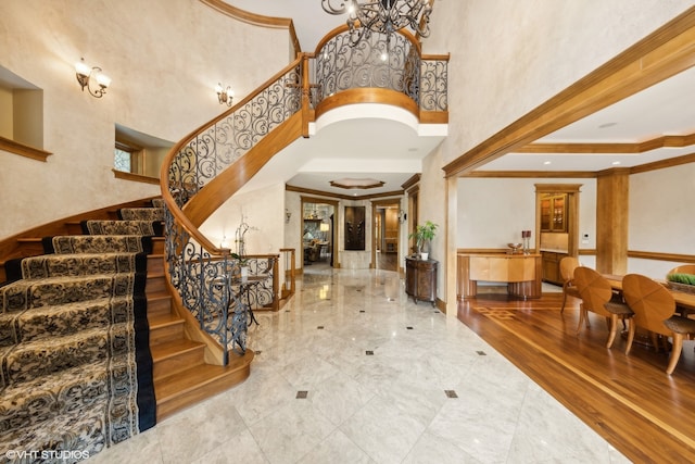 entryway featuring a notable chandelier, crown molding, a high ceiling, and hardwood / wood-style flooring