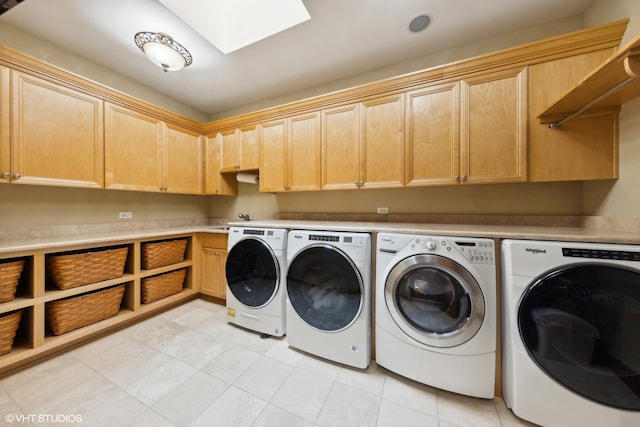 clothes washing area featuring cabinets and washing machine and dryer