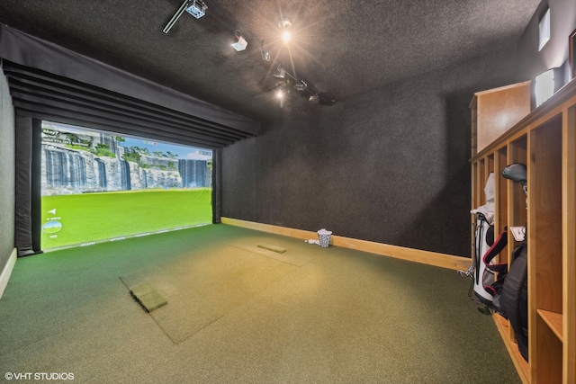 rec room featuring rail lighting, a textured ceiling, carpet flooring, and golf simulator