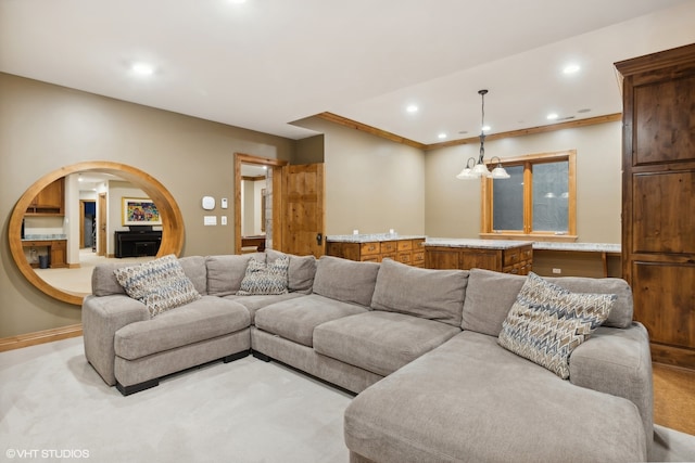 carpeted living room with crown molding and a notable chandelier