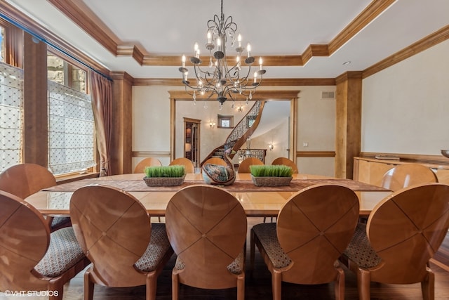 dining area with crown molding, hardwood / wood-style floors, and a chandelier