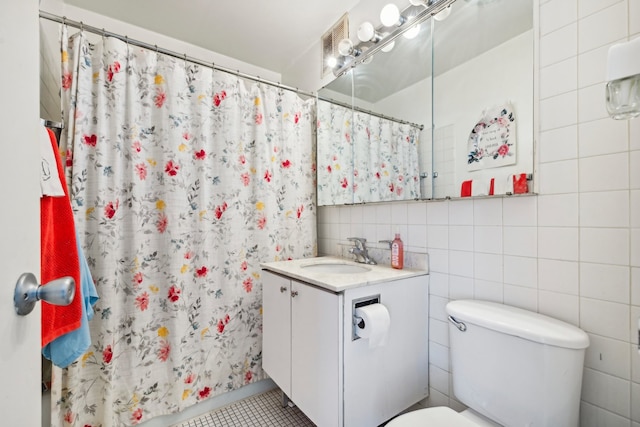 bathroom with vanity, toilet, a shower with curtain, tile walls, and tile patterned flooring