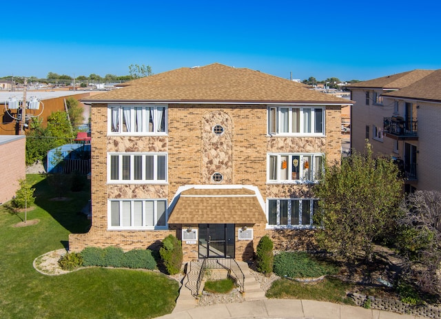 view of front of property with a front yard and a balcony