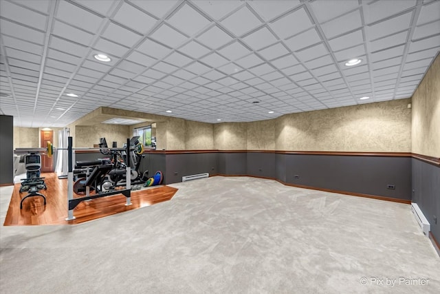 workout room featuring baseboard heating and hardwood / wood-style floors