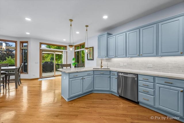 kitchen with dishwasher, light hardwood / wood-style floors, sink, kitchen peninsula, and hanging light fixtures