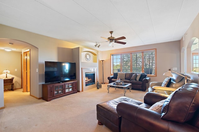 living room featuring light carpet, a wealth of natural light, and a tiled fireplace