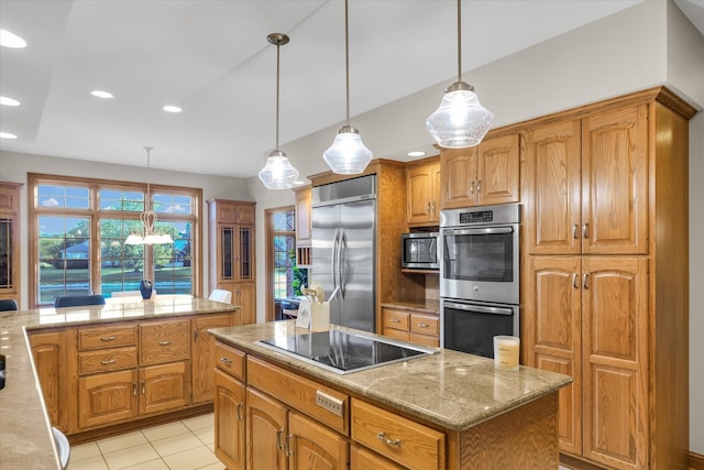 kitchen with a kitchen island, built in appliances, decorative light fixtures, and light tile patterned flooring