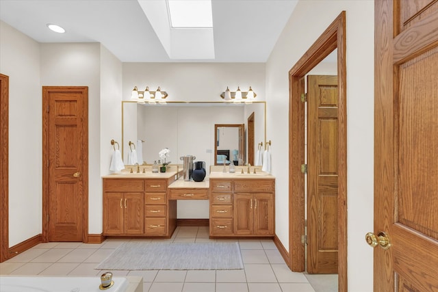 bathroom featuring vanity, a bathtub, tile patterned floors, and a skylight