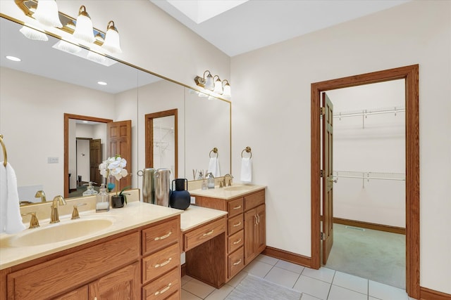 bathroom featuring vanity, tile patterned floors, and a skylight