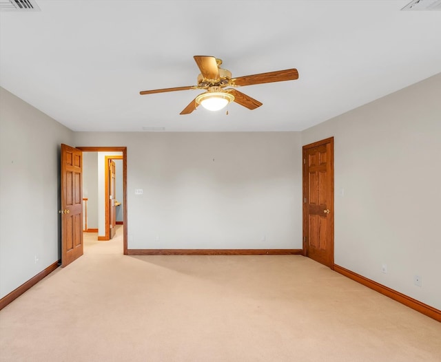 spare room featuring light colored carpet and ceiling fan