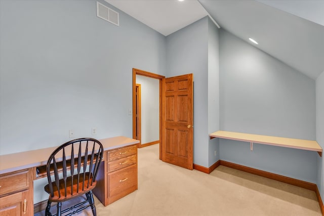 office area featuring built in desk, lofted ceiling, and light carpet