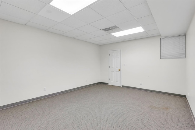 unfurnished room with a paneled ceiling and carpet flooring