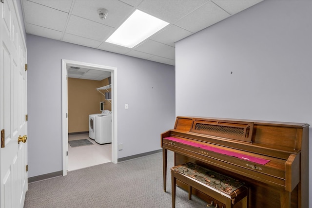 misc room featuring light carpet, a drop ceiling, and washing machine and clothes dryer