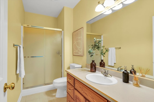 bathroom featuring a shower with door, toilet, vanity, and tile patterned floors