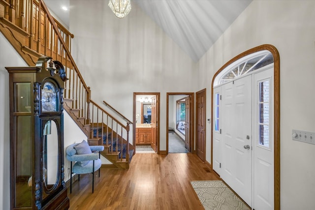 foyer with hardwood / wood-style flooring and high vaulted ceiling