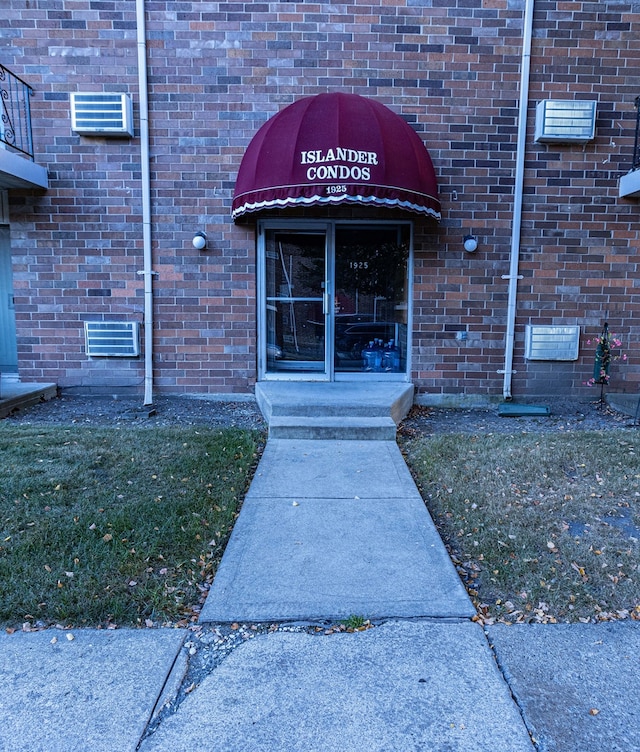 entrance to property featuring a lawn