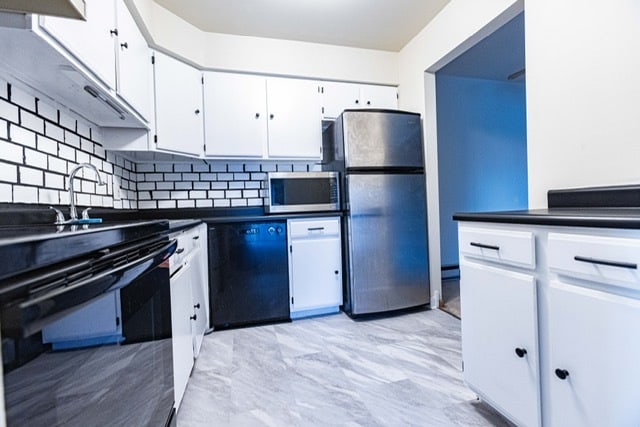 kitchen featuring white cabinetry, decorative backsplash, and black appliances