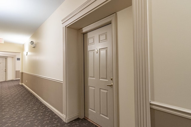 corridor featuring dark colored carpet