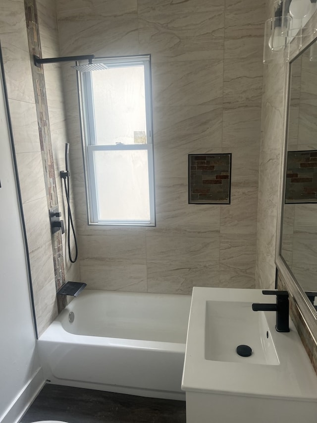 bathroom with tiled shower / bath and vanity