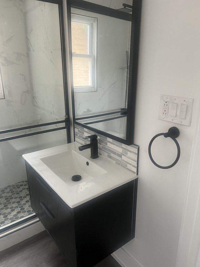 bathroom with vanity, tiled shower, tasteful backsplash, and hardwood / wood-style flooring