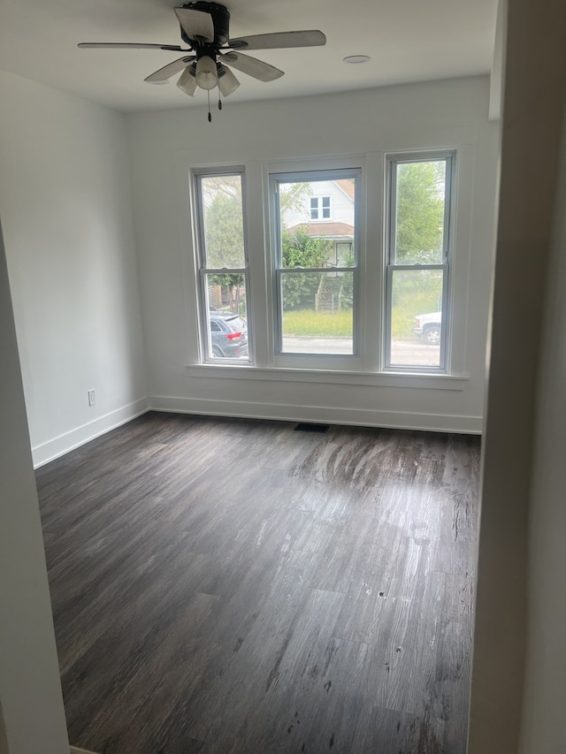 spare room with ceiling fan and dark hardwood / wood-style flooring