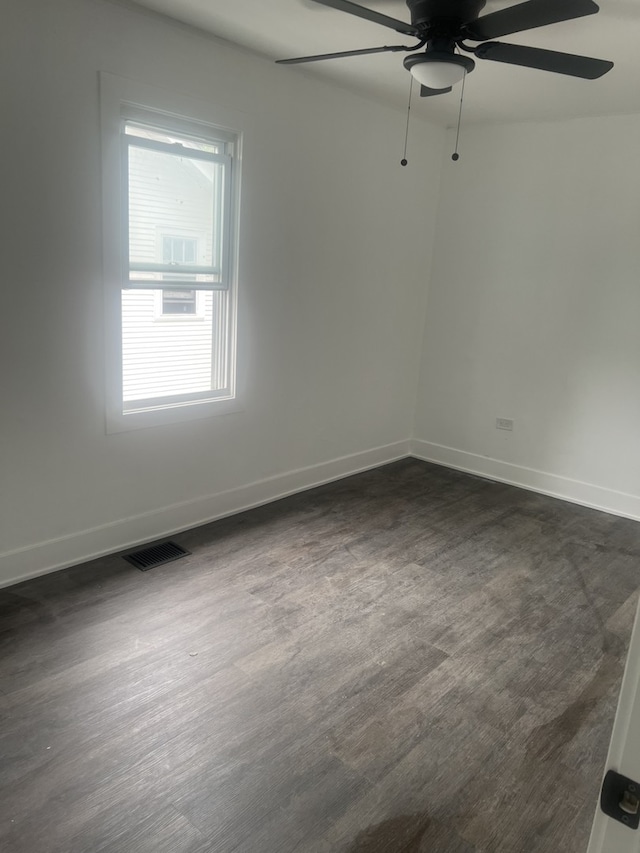 empty room featuring ceiling fan and dark hardwood / wood-style floors