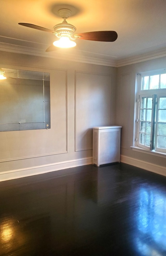 empty room featuring ceiling fan, dark wood-type flooring, and crown molding