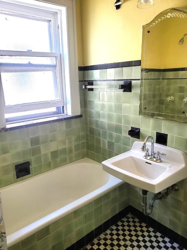 bathroom featuring tiled tub and sink