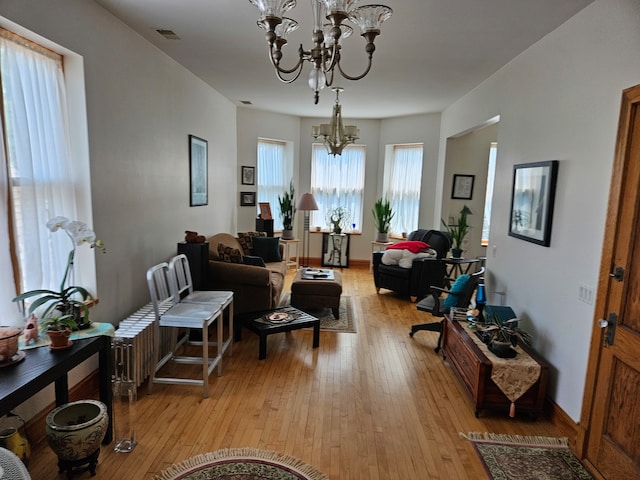 living room with a notable chandelier and light hardwood / wood-style floors