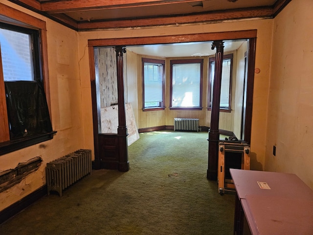 hall featuring dark carpet, beamed ceiling, and radiator