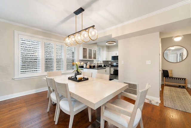 dining area featuring ornamental molding, sink, and dark hardwood / wood-style floors