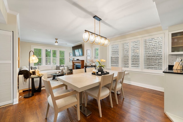 dining area with ceiling fan with notable chandelier, dark hardwood / wood-style floors, and crown molding